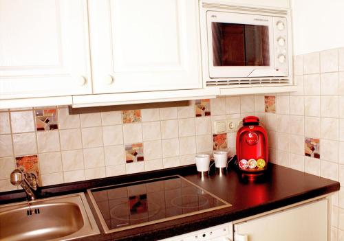 una cocina con un aparato rojo en una encimera en AppartementPension Zum Zacherl, en Feldkirchen