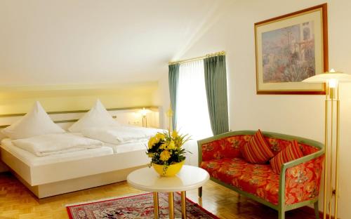 a hotel room with a bed and a couch at AppartementPension Zum Zacherl in Feldkirchen