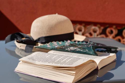 a hat sitting on top of a pile of books at Casa Provence Family & Friends Mare & Natura in Alghero