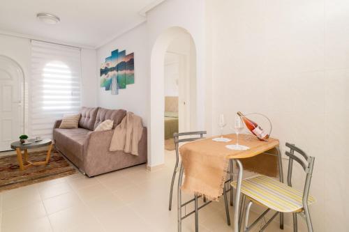 - un salon avec une table et un canapé dans l'établissement Espanatour AZAHAR DEL MAR, à Torrevieja