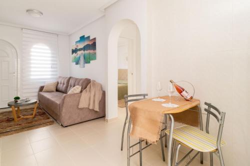 a living room with a table and a couch at Espanatour AZAHAR DEL MAR in Torrevieja