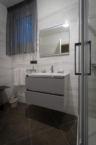 a bathroom with a white sink and a mirror at Residenza San Flaviano, Relais di Charme in LʼAquila