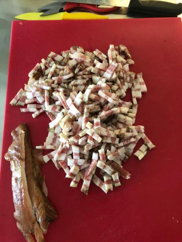 a pile of chopped up food on a red cutting board at mammaCristina in Patti