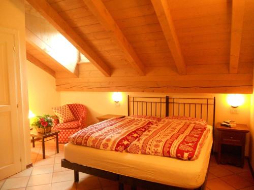 1 dormitorio con 1 cama y 1 silla en Residence Villa Avisio, en Canazei