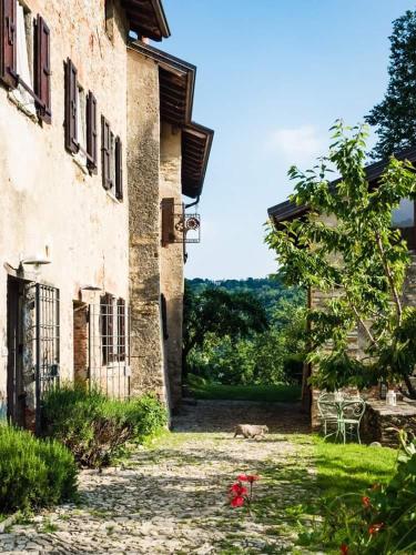 an old building with a dog sitting next to it at Agriturismo La Costa - Casa Vacanze in Perego