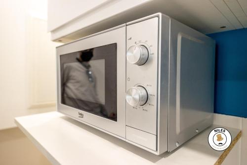 un four micro-ondes sur un comptoir avec une personne à l'intérieur dans l'établissement AUSTUDIO, à Pau