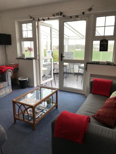 sala de estar con sofá y mesa de cristal en Finn McCools Giants Causeway Hostel, en Bushmills