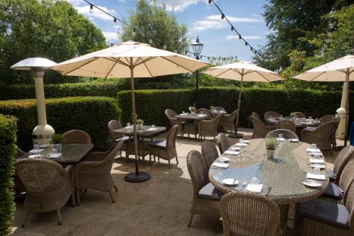 a patio with tables and chairs and umbrellas at Hotel Du Vin & Bistro Tunbridge Wells in Royal Tunbridge Wells