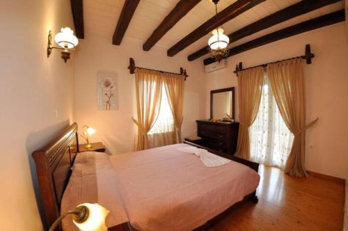 a bedroom with a large bed and a window at Villa Leo Junior in Áno Korakiána