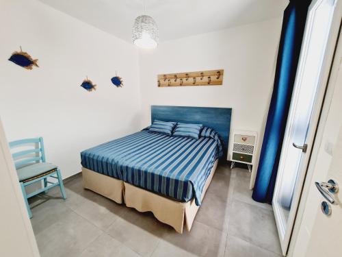 a bedroom with a bed and a chair in it at Finn House in Torre Lapillo