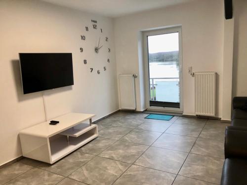 a living room with a flat screen tv on a wall at Dachgeschosswohnung mit Seeblick in Ahrensbök