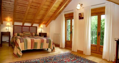a bedroom with a bed and a large window at Casa Rural Las Verdes l y II in Torre de Babia