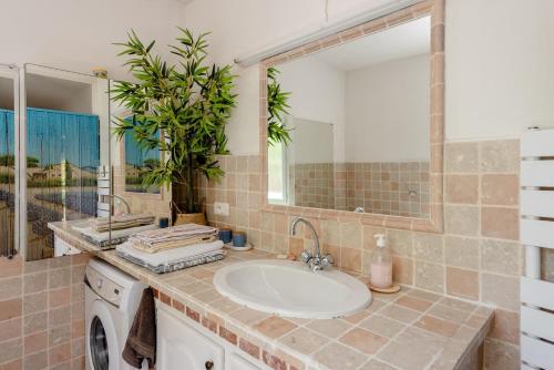 une salle de bain avec un lavabo et une machine à laver dans l'établissement Villa CHRISALB 1, à Aix-en-Provence