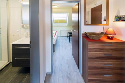 ein Badezimmer mit einem Waschbecken und einer Theke mit einem Spiegel in der Unterkunft Ferienwohnung Likedeelers in Norddeich