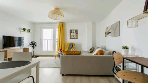 a living room with a couch and a table at Luxury Apartment near Paris la Défense with secured Parking in Bois-Colombes