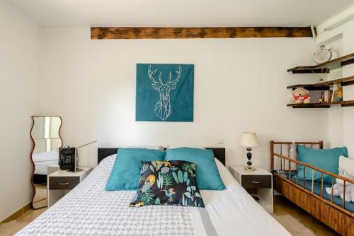 une chambre avec un lit blanc avec des oreillers bleus dans l'établissement Villa CHRISALB 1, à Aix-en-Provence