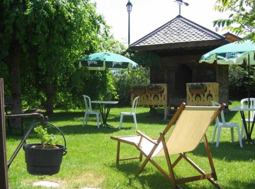 un cortile con sedie, tavolo e ombrellone di Chalet Bois Vallons Chambres d'Hôtes a Morzine