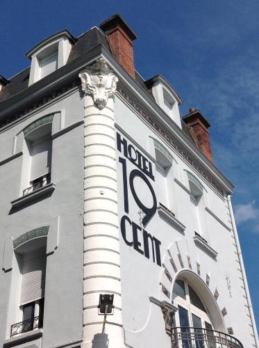 a white building with a sign on the side of it at Hôtel 19'Cent in Le Creusot