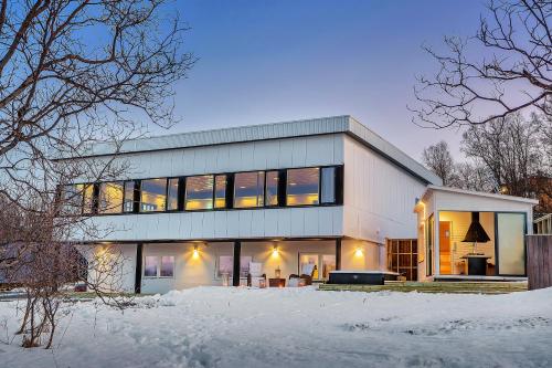 a large white house with a lot of windows at Robukta Lodge l Jacuzzi l Sauna l Table Tennis in Tromsø