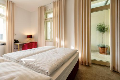 a bedroom with two beds and a window at Dvorec Gregorčič in Smarjeske Toplice