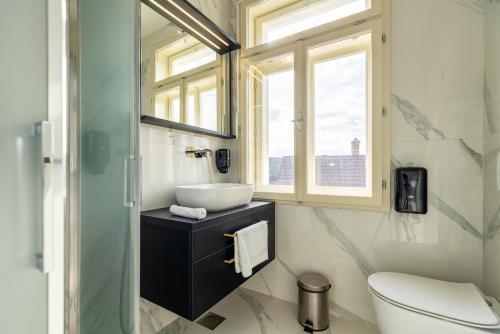 a bathroom with a sink and a toilet and a window at Dvorec Gregorčič in Smarjeske Toplice