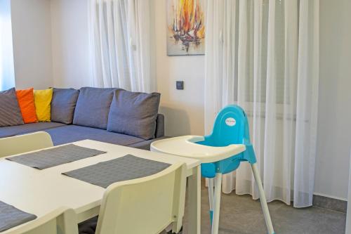 a living room with a couch and a table and chairs at Stile Suite Family Hotel in Antalya