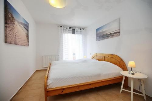 - une chambre avec un grand lit et une table dans l'établissement Neuer Weg 1 b Wohnung Haron, à Boltenhagen