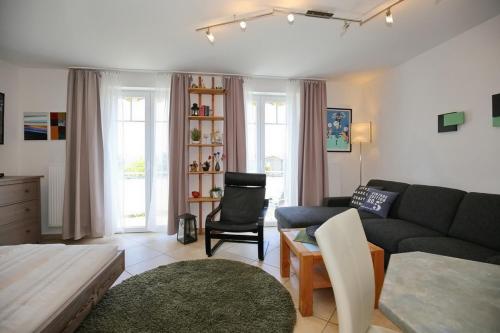a living room with a couch and a chair at Achtern Diek Wohnung 17 in Boltenhagen