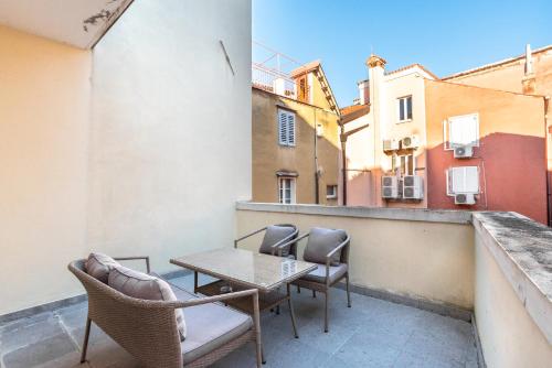 a patio with a table and chairs on a balcony at Art Hotel Tartini in Piran