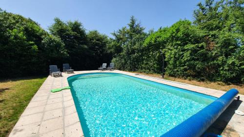 - une piscine avec 2 chaises dans l'établissement Gîtes Goas Teriot - Le Granit, à Locarn