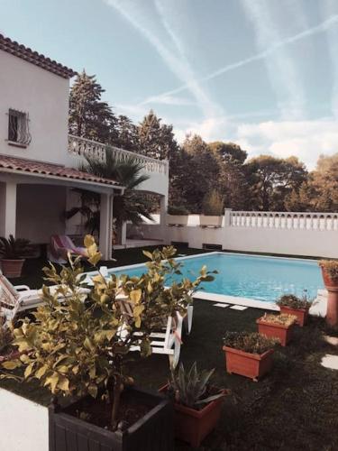 - une piscine dans une cour avec des chaises et des plantes dans l'établissement Villa CHRISALB 1, à Aix-en-Provence
