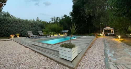 une arrière-cour avec une terrasse en bois et une piscine dans l'établissement La Mansardiere, à Villecroze