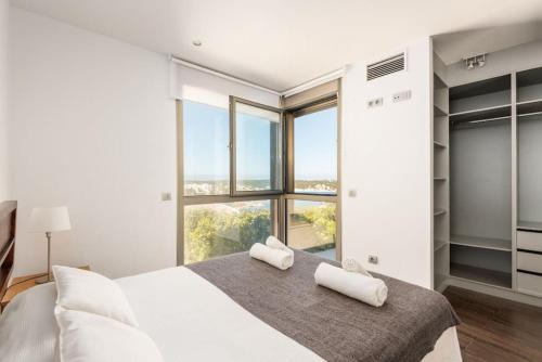 una camera da letto con un grande letto bianco e finestre di Blue Port a Mahón
