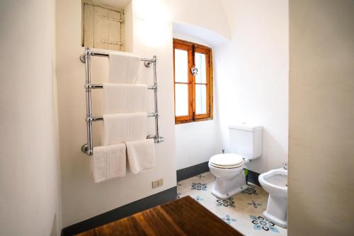 a bathroom with a white toilet and towels at Dormiusa in Bordighera