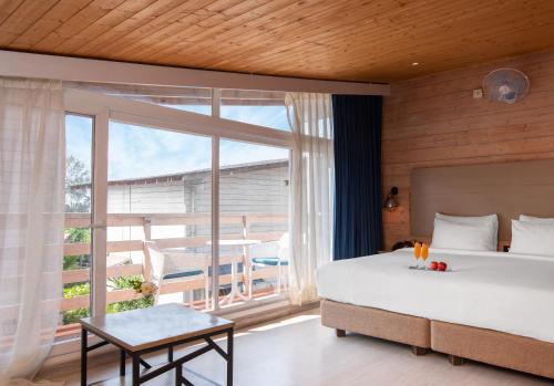 a bedroom with a large bed and a large window at Living Room Beach Resort in Morjim