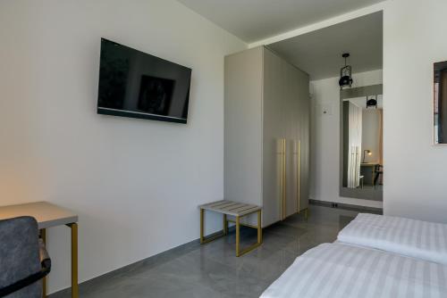 a bedroom with two beds and a tv on the wall at Dvorec Gregorčič in Smarjeske Toplice