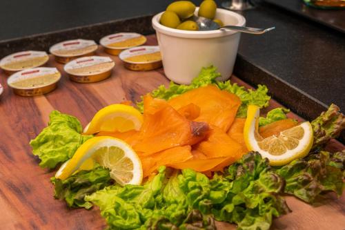 a cutting board with vegetables and oranges and lettuce at Lake Front Hotel Mirage in Riva del Garda