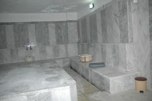 a bathroom with two toilets and a stone wall at Arora Hotel in Kusadası