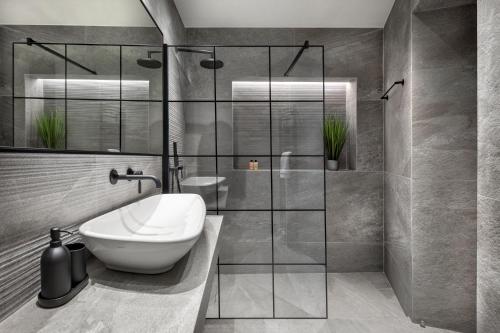 a bathroom with a sink and a glass shower at J&A Luxury Residence in Athens