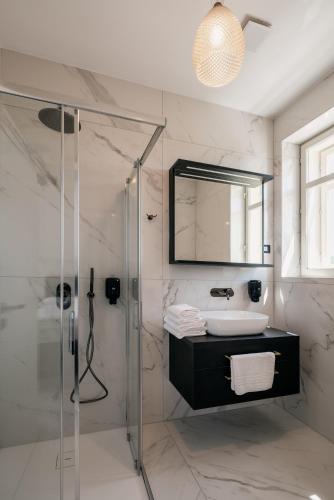a bathroom with a shower and a sink and a mirror at Dvorec Gregorčič in Smarjeske Toplice