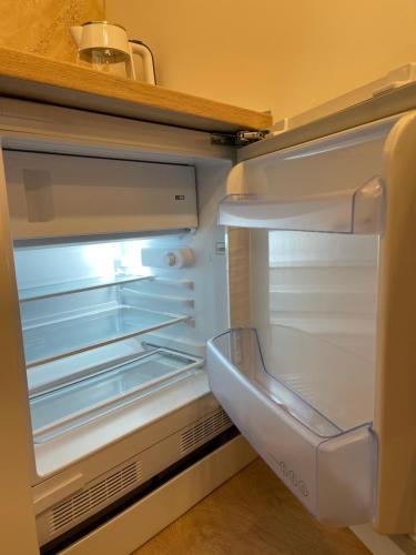 an empty refrigerator with its door open in a kitchen at Honey Valley Bjelašnica in Bjelašnica