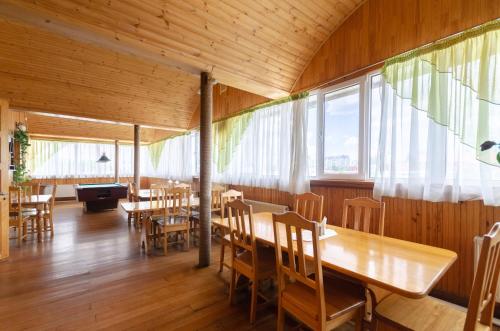 ein Restaurant mit Holztischen, Stühlen und Fenstern in der Unterkunft Тиса Економ in Kiew