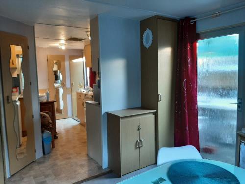 une pièce avec une cuisine et un salon dans l'établissement Mobilhome Châlet 4 personnes, 50 m de l'océan, à Le Port-des-Barques
