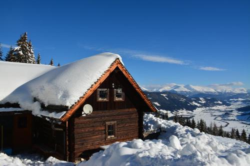 a cabin covered in snow on a mountain at Wurzelhütte in Sankt Margarethen im Lungau