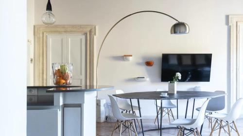 a dining room with a table and chairs and a tv at Pgrhome Luxury Apartments Domus Pantheon in Rome