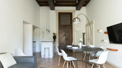 ローマにあるPgrhome Luxury Apartments Domus Pantheonのダイニングルーム(テーブル、白い椅子付)