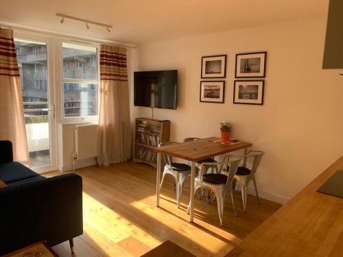 a living room with a wooden table and chairs at Farriers House in London