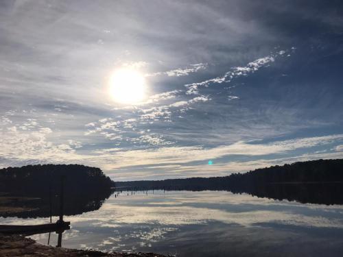 a view of a lake with the sun in the sky at Alpine Lakeview Motel Room WiFi,Sandy beach Boat Ramp,Pier,Marina,Bath House with Laundromat in Hemphill