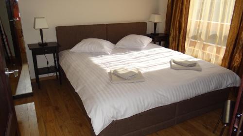 a bed with two books on top of it at De Lux Appartement in Druskininkai