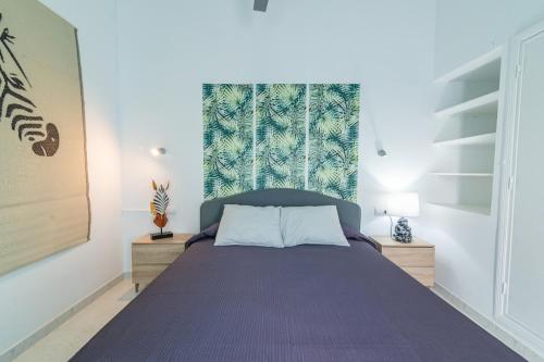 um quarto com uma cama com uma colcha roxa em Deluxe Duplex Bungalow Private Parking em Maspalomas